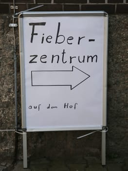 Signpost to the fever center in the courtyard during the corona virus pandemic