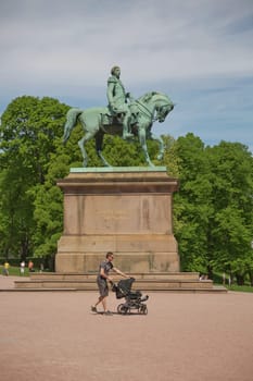 OSLO, NORWAY - MAY 27, 2017: People visiting and enjoying the Royal Palace and statue of King Karl Johan XIV in Oslo, Norway.