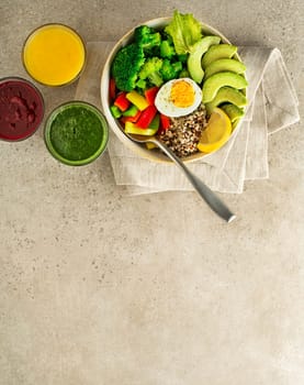 Healthy salad meal with quinoa, egg, avocado and mixed fresh vegetables on grey background top view. Food and health. Healthy meal concept