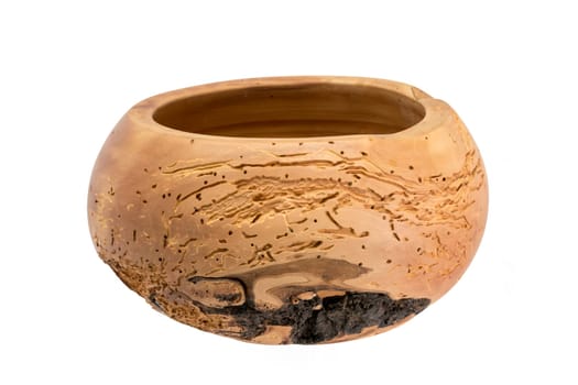 Hand-turned wooden bowl made of light worm-eaten wood isolated on white