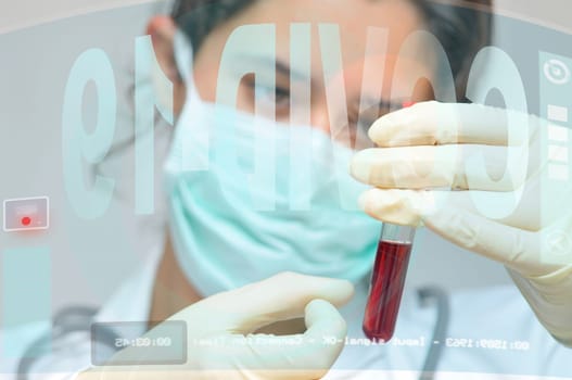 Young doctor analyzing a blood sample. Researching Corona virus cure, with digital screens
