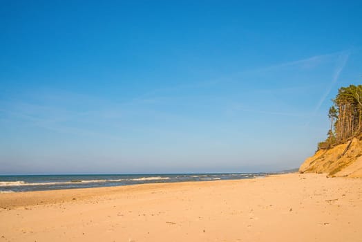 lonesome beach of the Baltic Sea with blue sky and surf