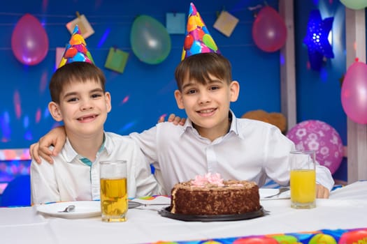 Two brothers hug each other while sitting at the festive table
