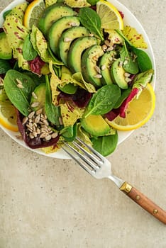 Healthy green salad with avocado and seeds close up