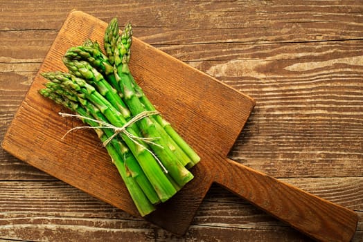 Asparagus. Fresh Asparagus. Pickled Green Asparagus. Bunches of green asparagus on wooden table, top view- Image