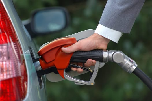 Man pumping petrol with fuel pump. Vehicle fueling facility at petrol station. Petrol price goes down after pandemic coronavirus. low price of fuel.