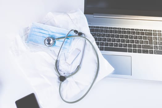 Home Office Medicine - PC with mask, stethoscope for protection against virus, infection, diagnosis and documentation.