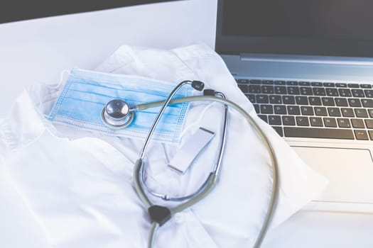 Home Office Medicine - PC with mask, stethoscope for protection against virus, infection, diagnosis and documentation.