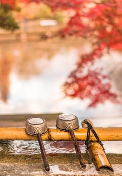 three water ladles on purification basin in the inokashira park of Kichijoji city in autumn.
