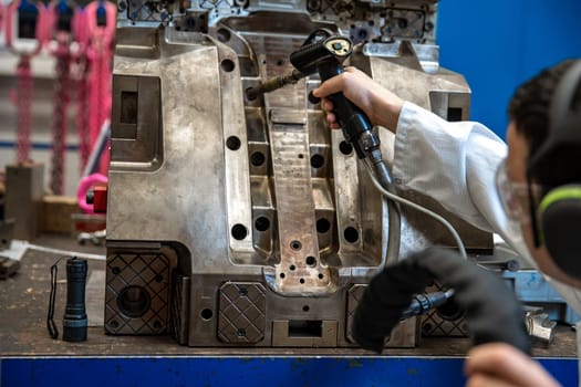 the engineer performs freezing of the casting using a special machine. maintenance of metal molds for plastic castings in the factory.