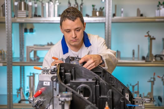 engineer measures plastic components for the production of lights for the automotive industry in a factory on a digital 3D machine.