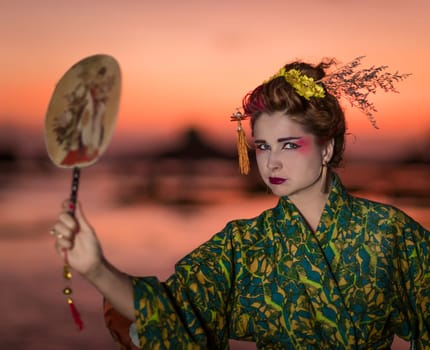 Fine art portrait of european woman in Japanese Geisha style wearing kimono
