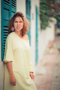 Outdoor portrait of a beautiful woman next to shutter window