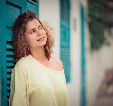 Outdoor portrait of a beautiful woman next to shutter window