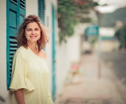 Outdoor portrait of a beautiful woman next to shutter window