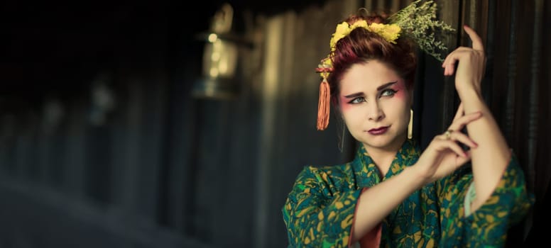 Fine art portrait of beautiful woman in Japanese Geisha style wearing kimono. Panorama