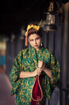 Fine art portrait of beautiful woman in Japanese Geisha style wearing kimono