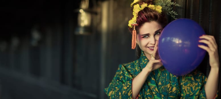 Fine art portrait of european woman in Japanese Geisha style wearing kimono with balloon