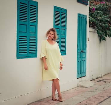 Outdoor portrait of a beautiful woman next to shutter window
