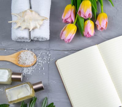 Spa with natural olive soap, tulips and sea salt and an open notebook for writing.