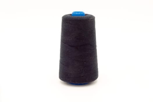 Close up of spool of colored thread on white background