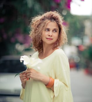 Outdoor portrait of a beautiful woman with flower