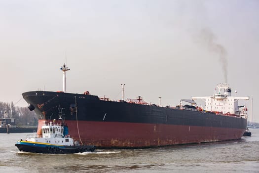 Big Cargo Containers Boat with Goods cargo Stack at the Pier docks port waiting for international sea freight transportation in Rotterdam Port of Netherlands
