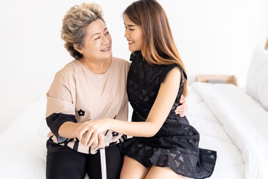 Cute young daughter embracing hug her happy old elderly mother with love at home