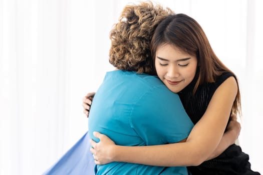 Cute young daughter embracing hug her happy old elderly mother with love at home