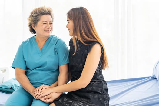 Cute young daughter embracing hug her happy old elderly mother with love at home