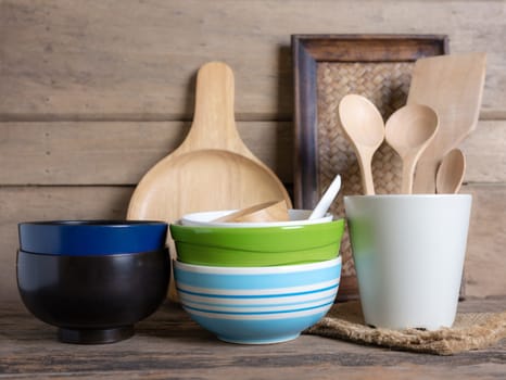 Rustic kitchenware against white wooden wall, Ceramic pot with wooden cooking utensil set