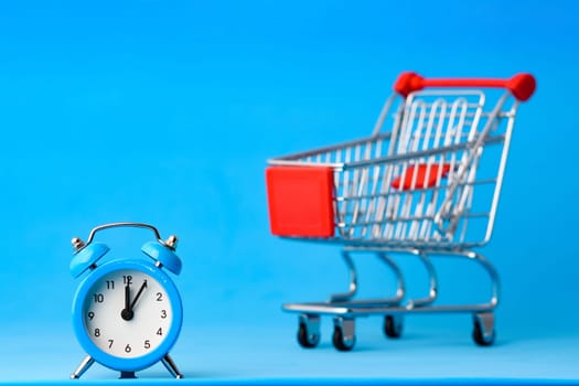 Clock in the foreground, a grocery cart blurry in the background