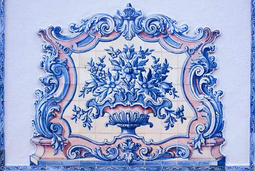 Lisbon, Portugal - March the 1st, 2020: Portuguese tin-glazed ceramic tilework decorates Lisbon walls. Vase made by Sant’Anna Factory