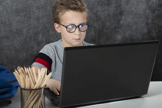 serious boy sitting with a laptop computer