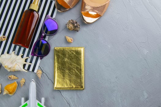Travel concept. Preparation for the tour: passport, women's shoes, plane, glasses, tanning oil and seashells.