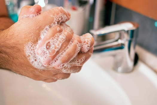Close view of washing hands with soap for prevention of germs, viruses and bacteria.