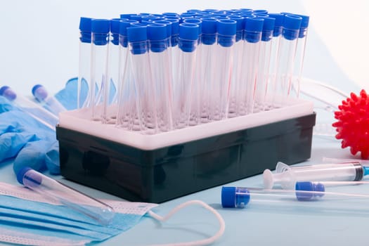 Several laboratory objects including protective mask, vial rack, testing tubes and other stuff.