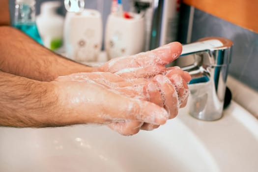 Close view of washing hands with soap for prevention of germs, viruses and bacteria.