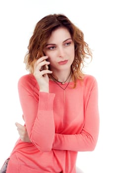 Portrait of cute joyful woman with trendy hairstyle wearing basic t-shirt talking on mobile phone isolated over white background.