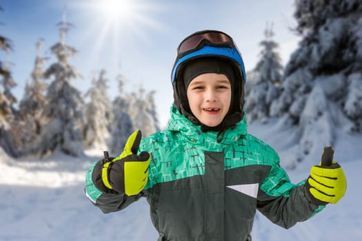 little boy on mountains in ski helmet with fallen first tooth, Czech Republic