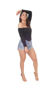 A lovely serious young woman standing in the studio with one hand on .her head, isolated for white background.