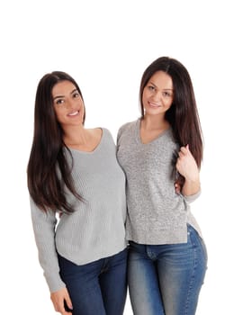 Two beautiful young woman standing site to site in jeans .looking at the camera, isolated for white background.