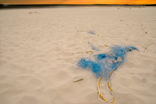 old fishing net on a beach with dramatic sky