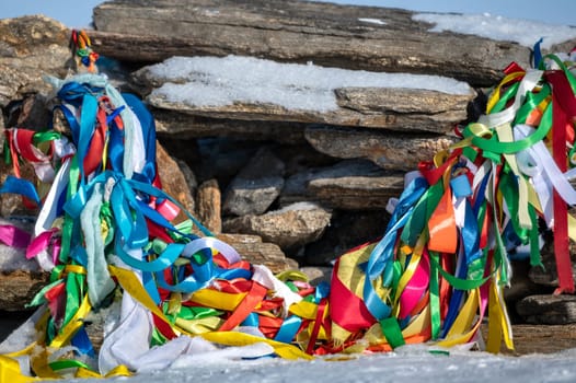 Sacred pillars with tied ribbons on Cape Burhan of Olkhon Island. Buryat traditions. Shamanistic and buddic rites of Lake Baikal. Olkhon Island, Baikal Lake , Buryatia republic Russia