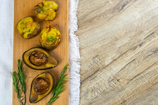 Flat lay composition with stuffed sweet bake potatoes and avocado on table.