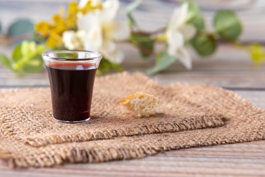 Taking communion concept - the wine and the bread symbols of Jesus Christ blood and body. Easter Passover and Lord . Focus on glass.