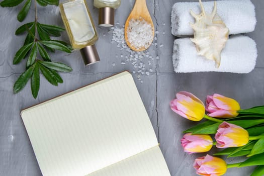 Spa with natural olive soap, tulips and sea salt and an open notebook for writing.