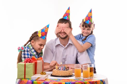 Children prepare a holiday surprise and light candles on a cake