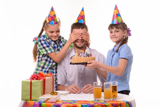 The children closed their eyes to dad and prepared a surprise for him in the form of a cake with candles