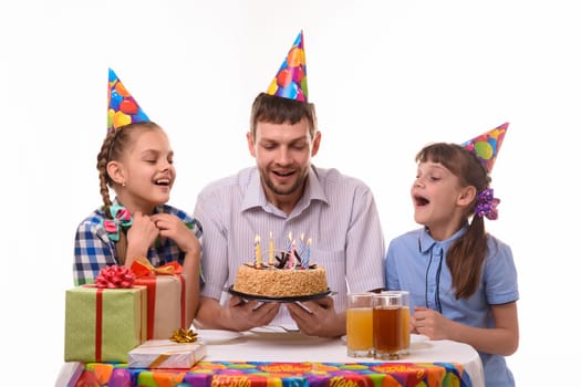Dad and two daughters took a little more air to blow out the candles on the holiday cake